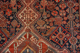 Antique Qashqai rug detailed with stylized animal and plant motifs in madder red, navy, and ivory.