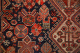 Intricate tribal patterns of stylized animals and plants in navy, madder red, and ivory pile.