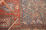 Detail of antique Caucasian rug, combining madder red lattice with sky blue geometric pinwheel motifs.