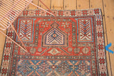 Antique Caucasian Prayer fragment rug displaying a red mehrab, lattice, germinating trees, and even pile wear.