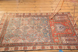 Antique Caucasian rug detail: geometric lattice design and madder red mehrab motifs.