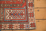 Madder root red, beige, and blue geometric border and fringed corner of antique Caucasian rug.