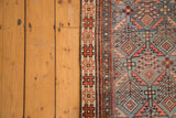 Antique Caucasian Prayer rug detail with madder red geometric border and blue lattice design.