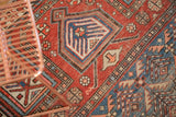 Antique Caucasian rug's red field, geometric lattice, pinwheel motif, and germinating plant design.