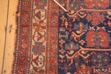 Antique Afshar rug's geometric red border and navy field with visible wear and an animal motif.