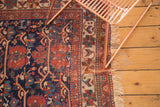 Antique Afshar rug corner, displaying cherry red geometric borders and softened fringe.