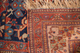 Detail of antique Afshar rug: navy blue field, cherry red geometric border, and worn fringe.