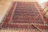 Close-up of antique Afshar rug's ivory border with boteh, pomegranates, and green selvage.