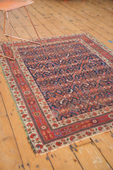 Antique Afshar rug corner shows boteh and pomegranate border, crude selvage, and worn pile.