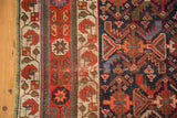 Antique Afshar rug's ivory main border featuring boteh, with dark field geometric design.