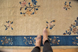 Ornate blossomed vinery on beige field meeting cobalt blue border of Peking carpet.
