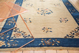 Antique Chinese carpet's cobalt blue border and beige field with delicate floral vinery.