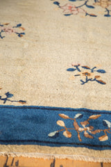 Art deco stylized Peking carpet: cobalt blue border vinery, beige field florals.
