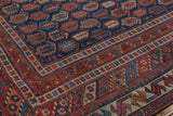Antique Afshar rug corner: navy field's staggered boteh design, multi-banded red and ivory border.