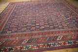 Antique Afshar carpet's intricate borders and geometric patterns in rich navy, red, and ivory.