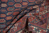 Antique Afshar rug corner, displaying navy, red, sky blue, and ivory geometric border patterns.