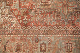 Vintage distressed Karaja carpet segment with geometric patterns in bronze, slate blue, and beige.