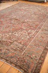 Distressed Karaja carpet corner, showcasing rectilinear bronze, slate blue, and ivory motifs.