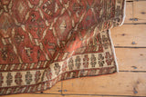 Vintage distressed Northwest Persian rug border, showing ivory floral motifs and rich red abrash.