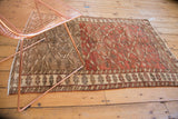 Distressed Northwest Persian rug border: ivory motifs, burnt red field, visible abrash and even wear.