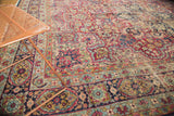 Antique Kerman carpet's intricate mil fleur field, showing cherry red and navy blue motifs.