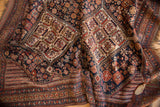 Antique Kamseh rug showing low pile and intricate navy, brick red, gold geometric patterns.
