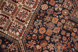Low pile of antique Kamseh rug, revealing stylized animal motifs on navy blue field.