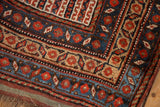 Antique Kamseh rug corner, geometric borders, stylized pomegranates, low pile in navy, brick red, gold.