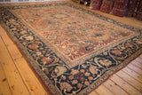 Ornate navy blue border with pale gold floral motifs on an antique Mahal carpet corner.