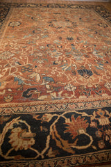 Rich navy blue border with stylized palmette and vine motifs on the Antique Mahal carpet.