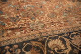 Intricate navy border with pale gold floral motifs on an antique Mahal carpet, showing worn chestnut field.