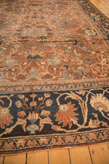 Antique Mahal carpet's navy border with chestnut and ivory floral motifs, showing wear.