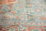 Distressed Mahal carpet detail: faded sky blue field, pale cranberry floral motifs, worn texture.