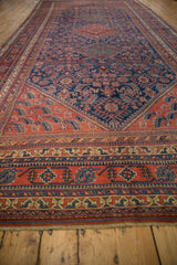 Angled view of a vintage Afshar runner highlighting its intricate red and indigo tribal border.
