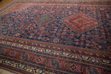 Angled view of the dense, herati-inspired motifs and tribal borders of a vintage Afshar rug.