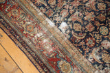 Antique Malayer rug detail: distressed Herati pattern with threadbare regions in indigo, wine, ivory.