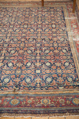Malayer rug's intricate indigo, red, ivory border motifs and gently aged fringe.