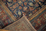 Folded corner of the antique Malayer carpet, revealing distressed Herati pile and hand-knotted foundation.