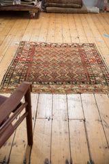 Secured fringe and intricate border of the antique Hamadan rug in red, beige, and black.
