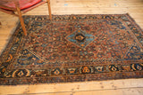 Antique Qashqai rug's lower border with rich madder red, navy, copper motifs, age-softened fringe.