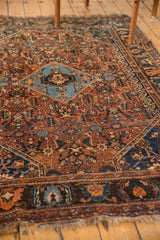Antique Qashqai rug's navy border with copper, sky blue geometric motifs and aged fringe.