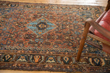 Antique Qashqai rug's Persian border and herati-inspired field in madder root red, navy blue.