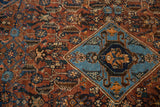 Detail of antique Qashqai rug's sky blue diamond medallion and madder red Herati field.