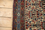 Vintage Kurdish Bijar rug fringe and patterned border, with ivory, sky blue, and madder red blooming plants.