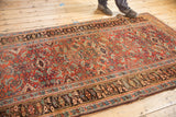 Antique Kurdish Bijar rug: madder root red Herati field, charcoal border, and even wear.