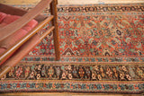 Madder root red herati motif field, oblong medallions, and etched charcoal border.