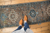 Geometric Karaja rug with distressed chocolate brown and blue medallion pattern.