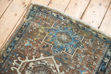 Distressed Karaja runner detail, blue geometric medallion with hook motif on brown field.