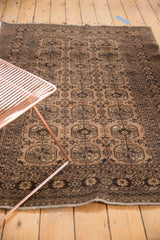 Distressed Afghan rug displaying triple column gul motifs in pale camel gold and chocolate brown with even wear.