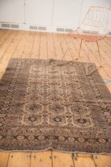Distressed vintage Afghan rug's bottom edge, with even wear to knot heads and patterned border.